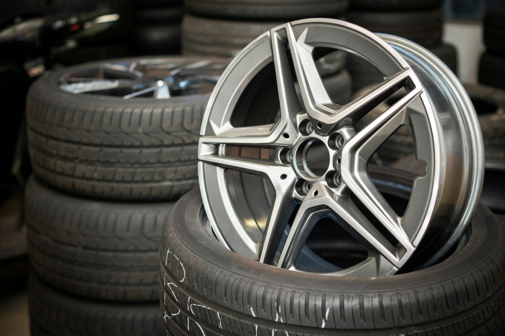 Car wheel rim placed on tire in workshop