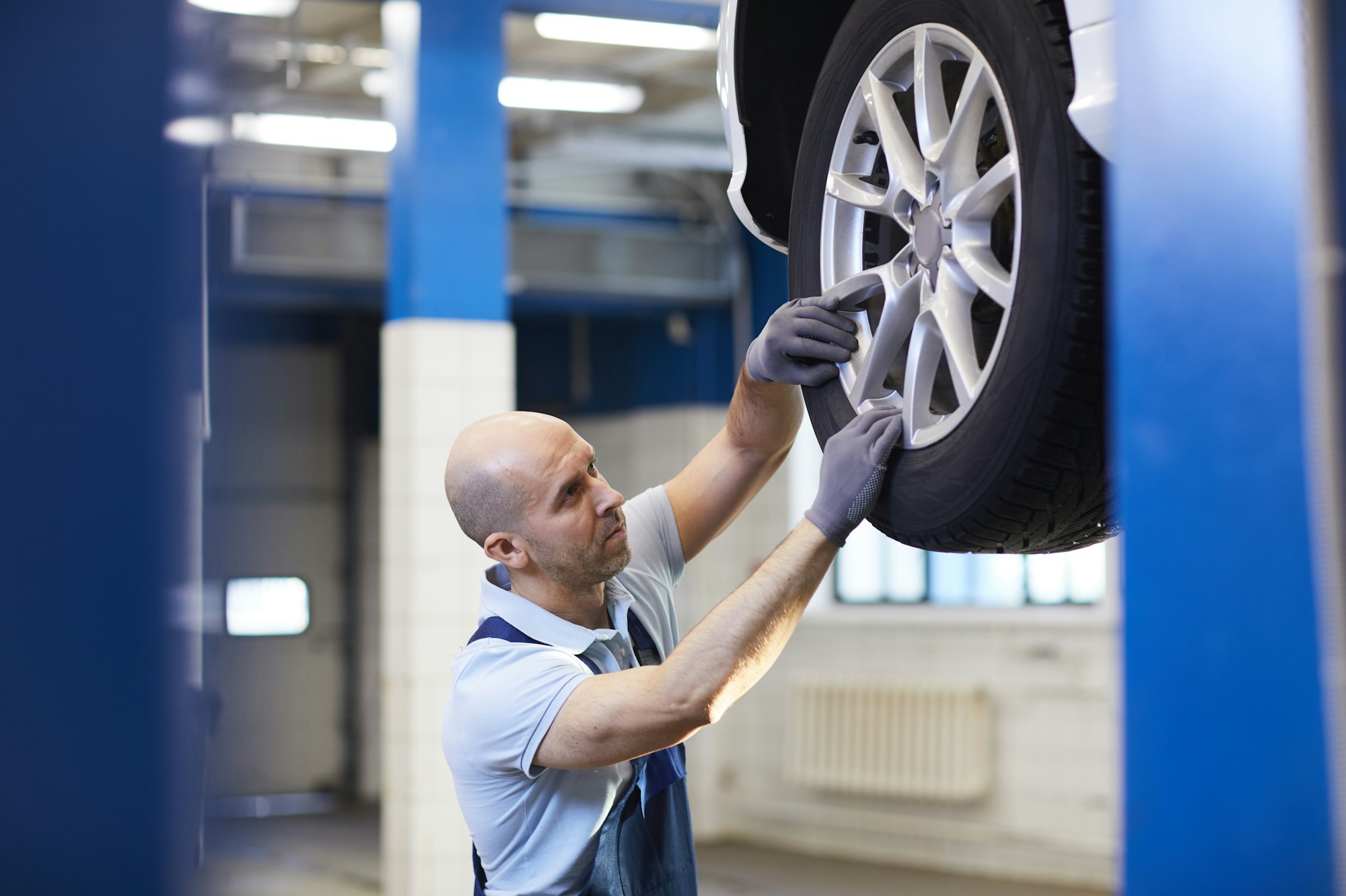 Mechanic Checking Wheels in Auto Shop